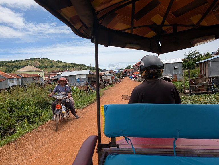 Pov's ‘Happiness Ride’ tuk-tuk on a red-dirt village road outside Siem Reap