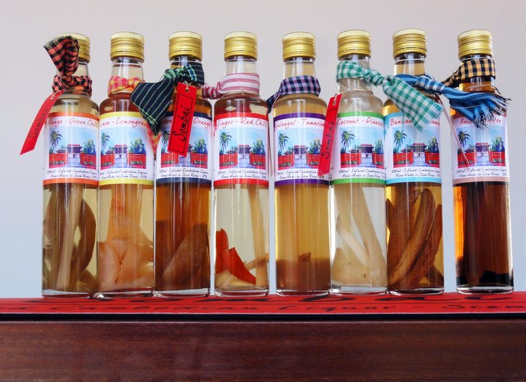 A row of colourful Sombai infused rice-wine bottles with fruit and spices inside.